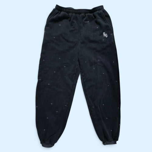 Rage U Athletics StarFall sweatpants — black heavyweight cotton fleece joggers with white star speckle print and embroidered RU logo on the left thigh